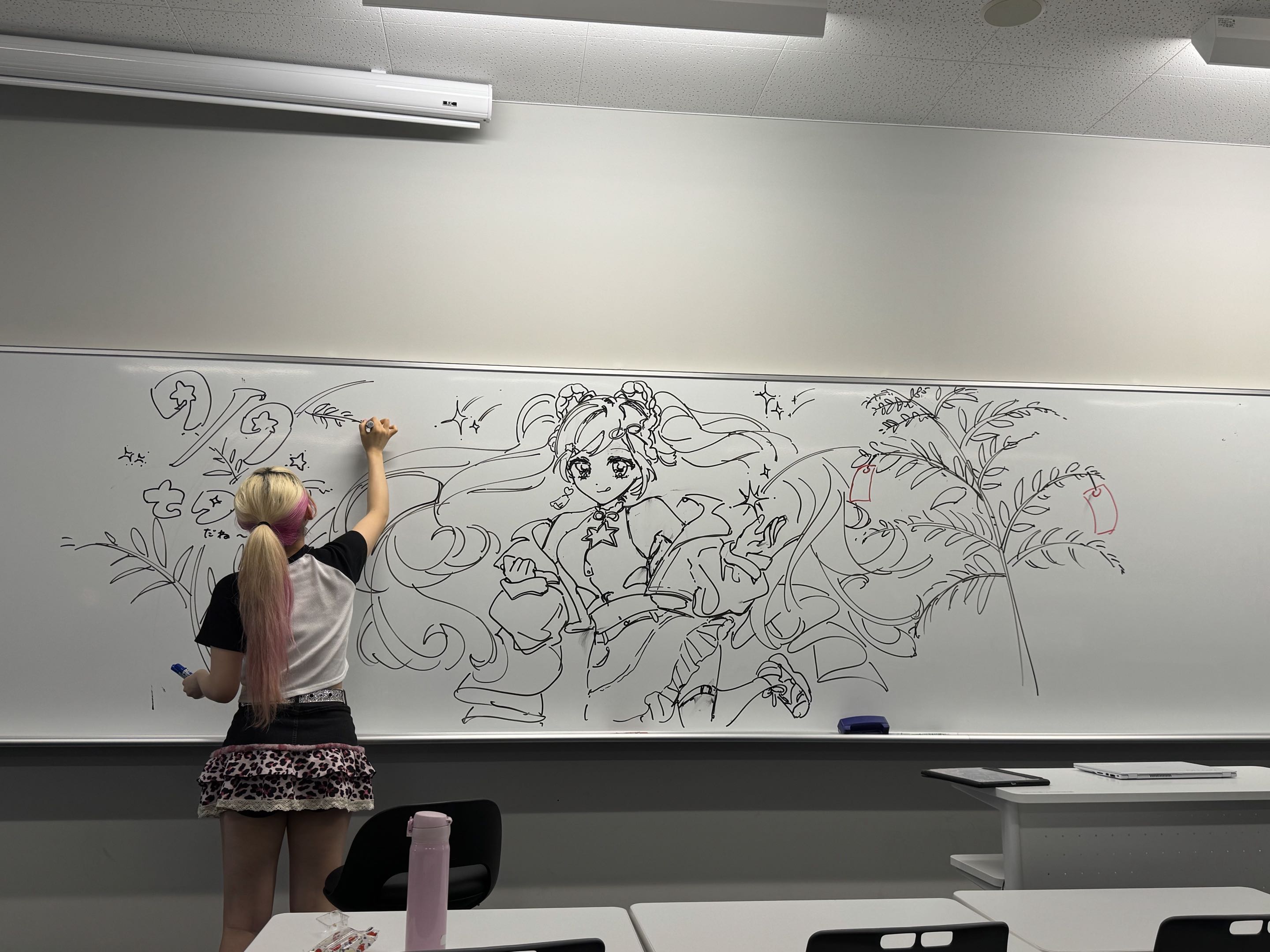 ホワイトボードにイラストを描く創作活動の様子